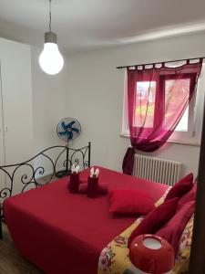 a bedroom with a red bed with red pillows at Lake Apartment Ischia Red, Lago di Caldonazzo in Tenna 