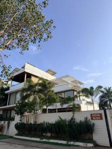 a large white building with trees in front of it at Nova Bliss Villa in Nashik