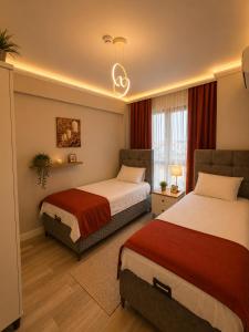 a hotel room with two beds with red curtains at Mahal house in Pelitli