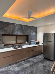 a kitchen with a stainless steel refrigerator and a ceiling at Nova Bliss Villa in Nashik