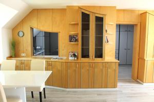 a kitchen with wooden cabinets and a white table at Royal Racing Suite Top 1 near Red Bull Ring in Judenburg