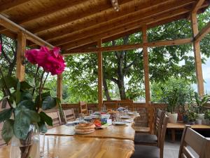 a wooden table with food and a rose in a vase at Ala-Archa Mountain House in Vorontsovskoye