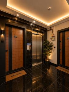 a lobby with two elevators and a potted plant at Mahal house in Pelitli