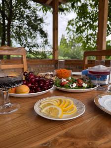 a wooden table with plates of food on it at Ala-Archa Mountain House in Vorontsovskoye