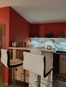 a kitchen with two white chairs and a counter at La suite mahradja in Quimper +25 photos