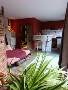 a red room with a bed and a kitchen at La suite mahradja in Quimper