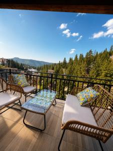 a balcony with chairs and tables and a view of the mountains at Monti Wellness & Spa Vlašić in Vlasic