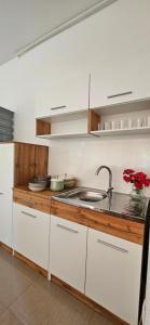 a kitchen with white cabinets and a sink at Nadia's home in Ilidža