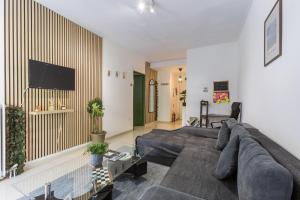 a living room with a couch and a flat screen tv at Varkiza Beach Summerhouse-Athens Riviera in Vari