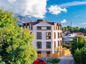an apartment building in a city with mountains in the background at Mini Condos 2 Studio-Loft with garden in Mrčevac