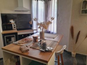 a table in a kitchen with a vase of flowers on it at Oasis in Agen +5 photos
