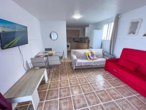 a living room with a red couch and a desk at Bungalow and private XXL Terrace in Alicante