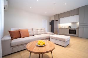 a living room with a couch and a table with a bowl of fruit at Anemi Residence in Chios
