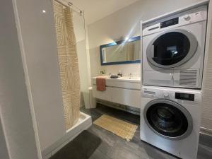 a washing machine in a bathroom with a sink at Oasis in Agen