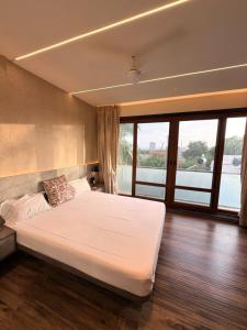 a bedroom with a large bed with a large window at Nova Bliss Villa in Nashik +33 photos