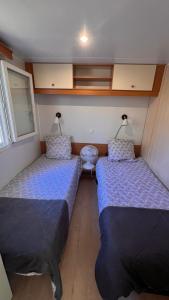 two beds in a small room with blue sheets at Les 3oliviers in Santa-Maria-Siché