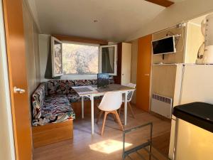 a small kitchen with a table and a couch in a tiny house at Les 3oliviers in Santa-Maria-Siché