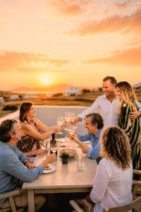 a group of people sitting around a table drinking wine at Orion Sea View Studio in Parasporos