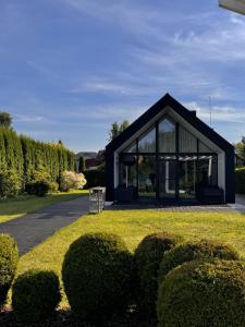 a black and white house with bushes in front of it at HARMONY Slow Living Stay in Bigauņciems