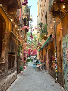 an alley with people sitting at a table in a city at Amarè House in Catania