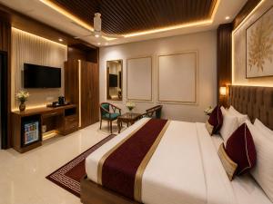 a hotel room with a large bed and a television at Hotel Montanaa Plaza Near Delhi Airport - Free Airport Pickup & Drop and Breakfast- Dinner complementary in New Delhi +25 photos