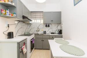 a kitchen with gray cabinets and a white counter top at Varkiza Beach Summerhouse-Athens Riviera in Vari