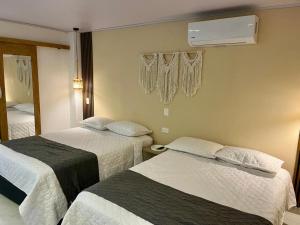 a hotel room with two beds and a air conditioner at Casa Arena San Andres in San Andrés