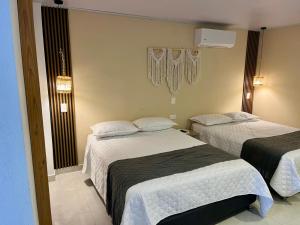 a hotel room with two beds and a television at Casa Arena San Andres in San Andrés