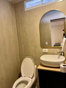 a bathroom with a toilet and a sink and a mirror at Casa Arena San Andres in San Andrés
