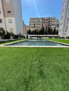 a large swimming pool in the middle of a grass field at rental per night in Nabeul