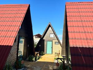 a group of three houses with orange roofs at Pousada Bellissima Italia in Luis Correia