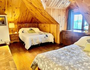 a bedroom with two beds in a room with wooden walls at Charmant appartement dans maison patrimoniale in Sherbrooke