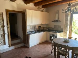 a kitchen with white cabinets and a table with chairs at Il Convento di Laura in Civitanova del Sannio