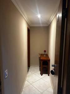 a hallway with a desk and a table in a room at Grande Hotel in Duque de Caxias