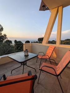 a patio with a table and chairs on a balcony at Harmony Sunset in Skala Sotiros