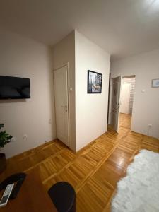 an empty living room with wooden floors and white walls at Balkan 024 in Subotica