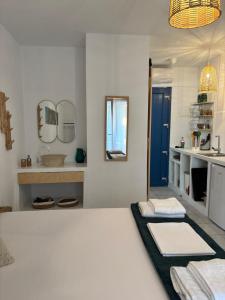 a bedroom with a bed and a sink and a mirror at 7Olives Emerald Boutique Apartment in Kastraki