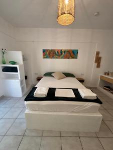 a white bedroom with a bed in a room at 7Olives Emerald Boutique Apartment in Kastraki