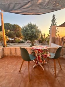 a table and chairs on a balcony with a view of a street at 7Olives Emerald Boutique Apartment in Kastraki