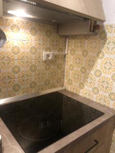 a kitchen with a black counter top and tiles at L'oasi dei larici - Montoso in Bagnolo Piemonte +19 photos