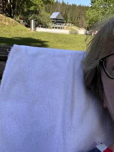 a woman with glasses sitting on a bench with a table at Ferienwohnung Laax mit Traumblick, großem Balkon und Terrasse in Laax +122 photos