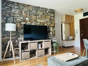 a living room with a tv on a stone wall at My Life 19 - Green Hill in Soko Banja