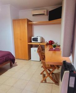 a small kitchen with a table and a microwave at Patio Prana Apart Resto in Federación