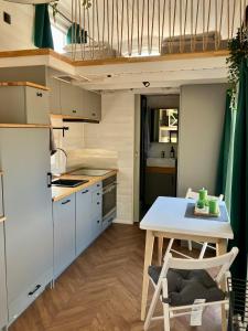 a kitchen with a table and a kitchen with a refrigerator at Fuchs und Igel Tiny House - Tiny House Fuchs in Möllensee