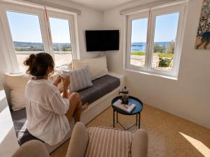 a woman sitting on a couch in a living room at Ni&Gio Sterna 1 in Parikia