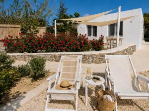 two chairs and a table and a house with flowers at Ni&Gio Sterna 1 in Parikia