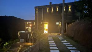 a house at night with the lights on at Avocado in Domingos Martins