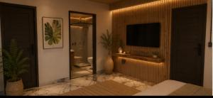 a bedroom with a television and a bathroom at Avocado in Domingos Martins