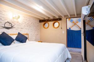 a bedroom with a large white bed with blue pillows at Coleção Falésias de Pipa- by Arcbio Experience in Pipa +24 photos