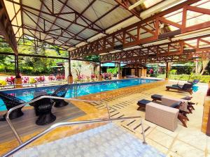 an indoor pool with chairs and a swimming pool at Ávita Lodge in Quesada